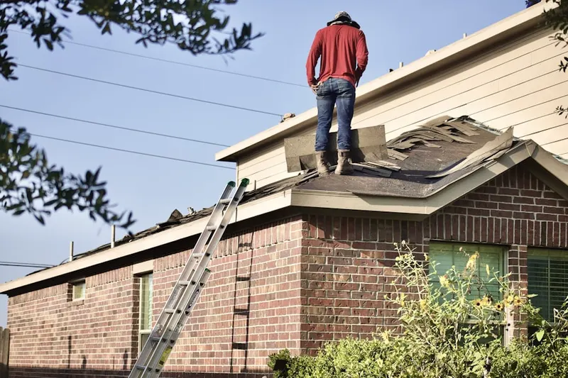 Professional roofer working on a residential roof in Elsmere